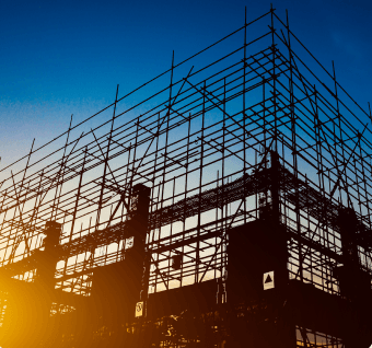 Chantier de construction avec structure métallique en cours de montage, représentant les projets de bâtiment et travaux publics.