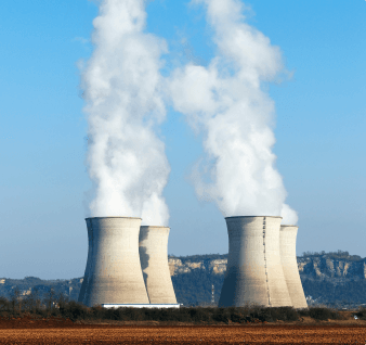 Centrales nucléaires avec vapeur s’échappant des tours de refroidissement, illustrant les projets énergétiques et industriels.